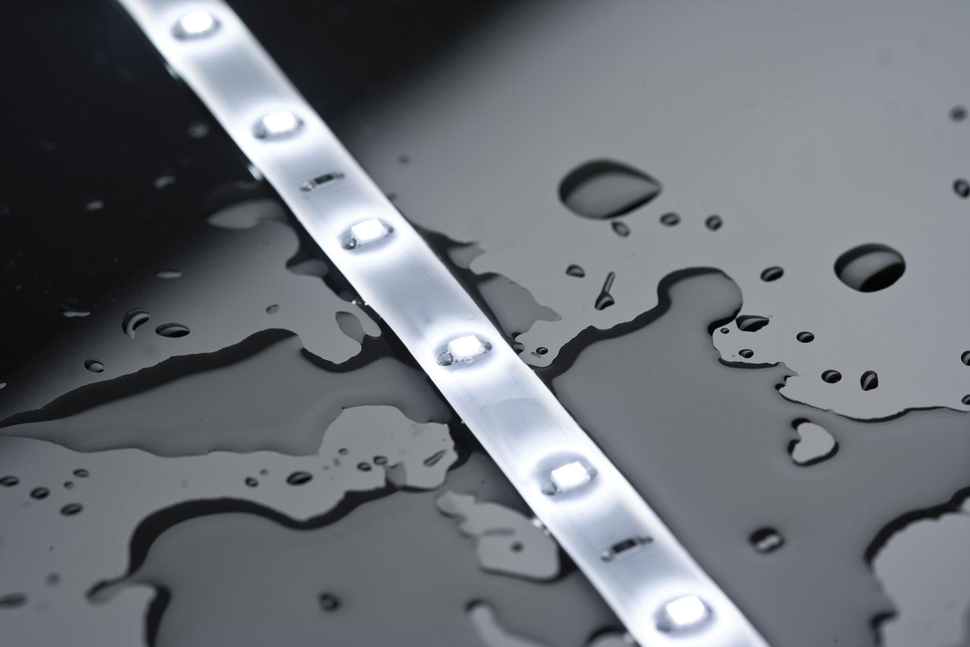 White LED strip light with waterproof protection on black surface for versatile lighting applications