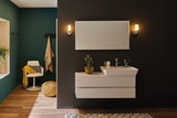 Salle de bain moderne avec lavabo blanc et meuble sur mur sombre, éclairée par des appliques LED.