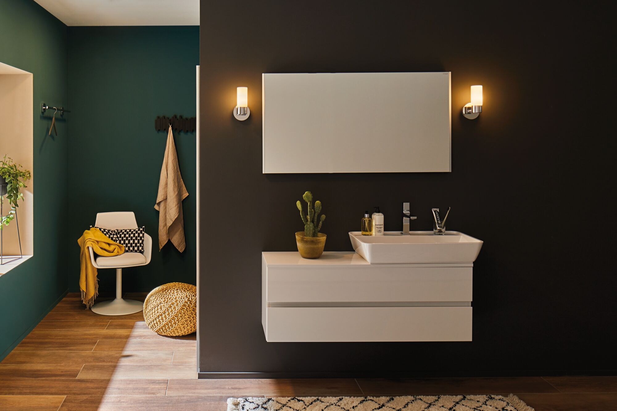 Modernes Badezimmer mit weißem Waschbecken und Schrank vor dunkler Wand, LED-Wandlampen beleuchten.