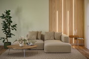 Beiges Sofa mit Kissen vor Holzlamellenwand mit integrierter LED-Beleuchtung im modernen Wohnzimmer