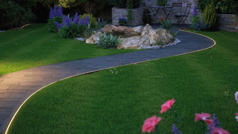 LED-Streifen für den Außenbereich laufen entlang des Wegrandes und hüllen ihn in ein warmes Licht. LED-Streifen für den Außenbereich von Paulmann