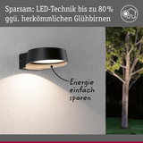Schwarze LED-Außenwandleuchte an weißer Wand mit energiesparender Beleuchtung und Baum im Hintergrund
