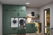 Modern green kitchen unit with washer, dryer, wooden countertop and LED ceiling light in laundry room