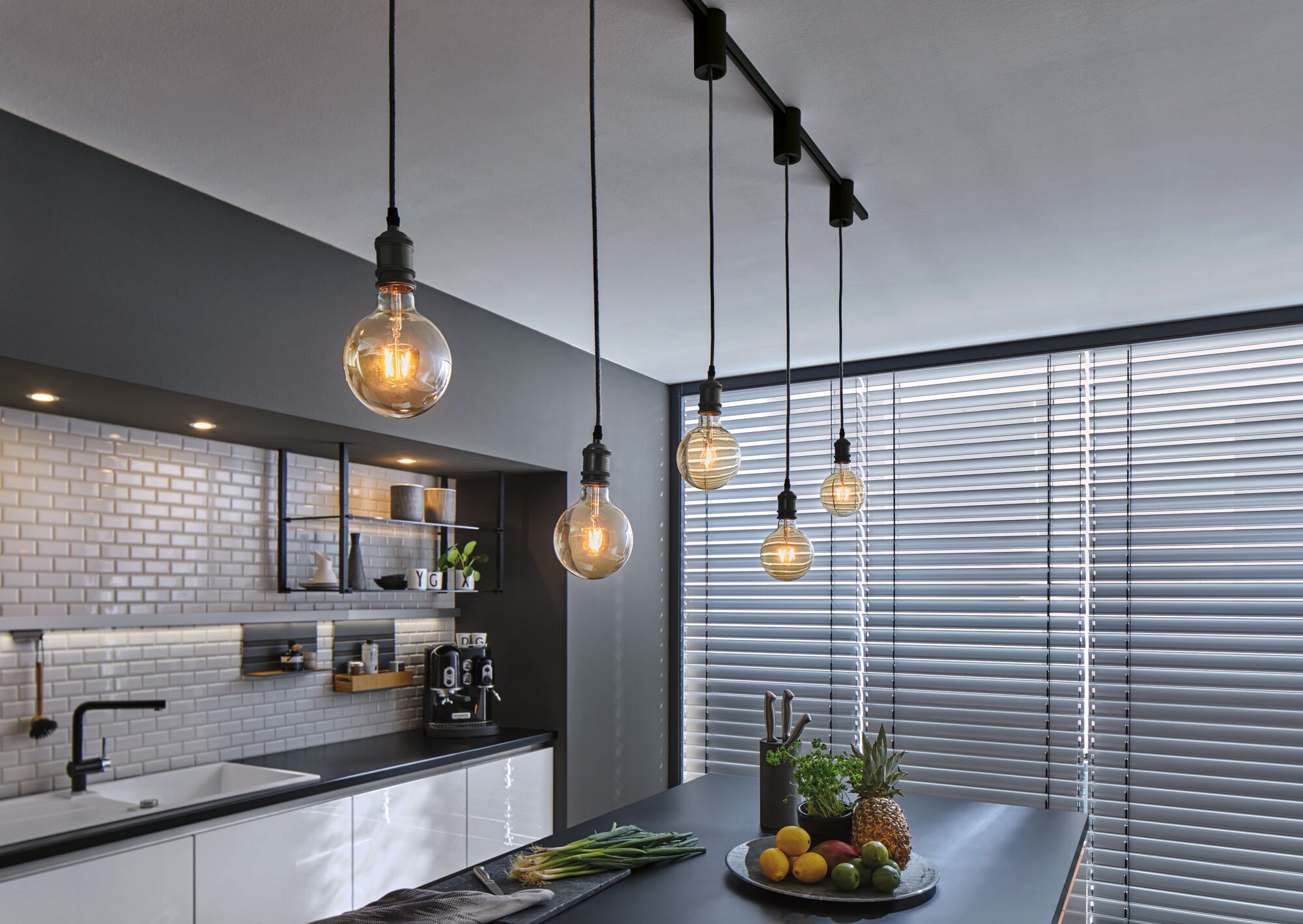 Moderne Küche mit schwarzen Pendelleuchten und weißen Fliesen, stilvolle LED-Beleuchtung für Wohnraum.