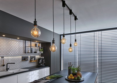 Moderne Küche mit schwarzen Pendelleuchten und weißen Fliesen, stilvolle LED-Beleuchtung für Wohnraum.