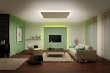 Salon moderne avec mur vert, mobilier beige et luminaire de plafond rectangulaire à lumière indirecte