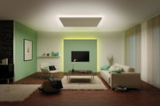Salon moderne avec mur vert, mobilier beige et luminaire de plafond rectangulaire à lumière indirecte