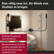 Schwarzes Stromkabel mit Stecker und Schalter vor beiger Wand für Wandbeleuchtungssystem