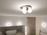 Moderne Deckenleuchte mit vier weißen Glaskugeln und Chromfassung in stilvollem Badezimmer.