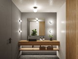 Modern bathroom with wooden vanity, black sink, and round wall lights in grey and wood design