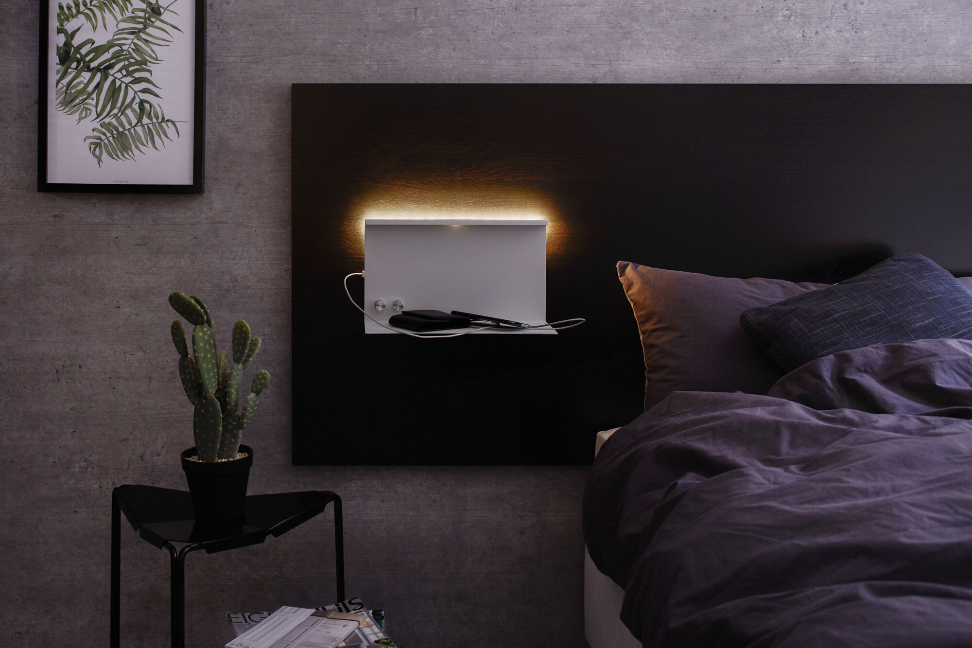 Moderne slaapkamer met zwart hoofdeinde en witte metalen LED-wandlamp met plankje voor apparaten.