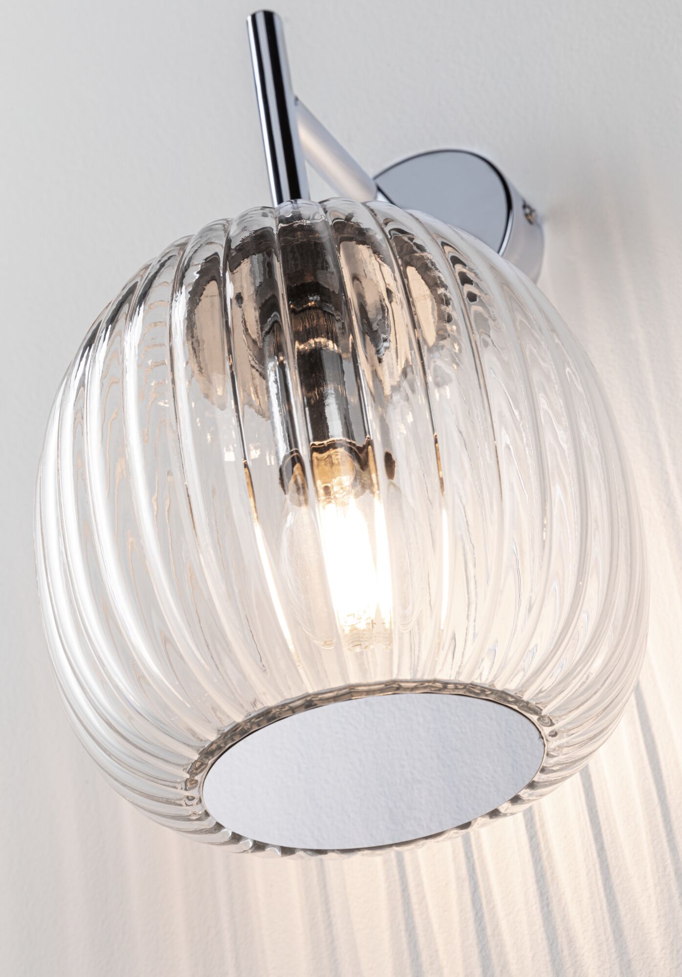Wandlampe mit geriffeltem transparentem Glas und verchromtem Metallhalter für modernes Wohnambiente