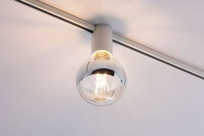 Moderner Deckenstrahler mit klarem Glaskugel-Schirm und weißem Metallgehäuse für Wohnräume.