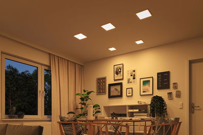 Living room with warm white square LED ceiling lights and modern beige and wood furniture design.